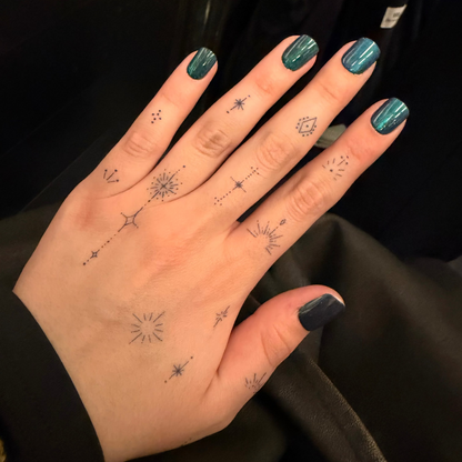 Hand with star-shaped tattoos on a black background